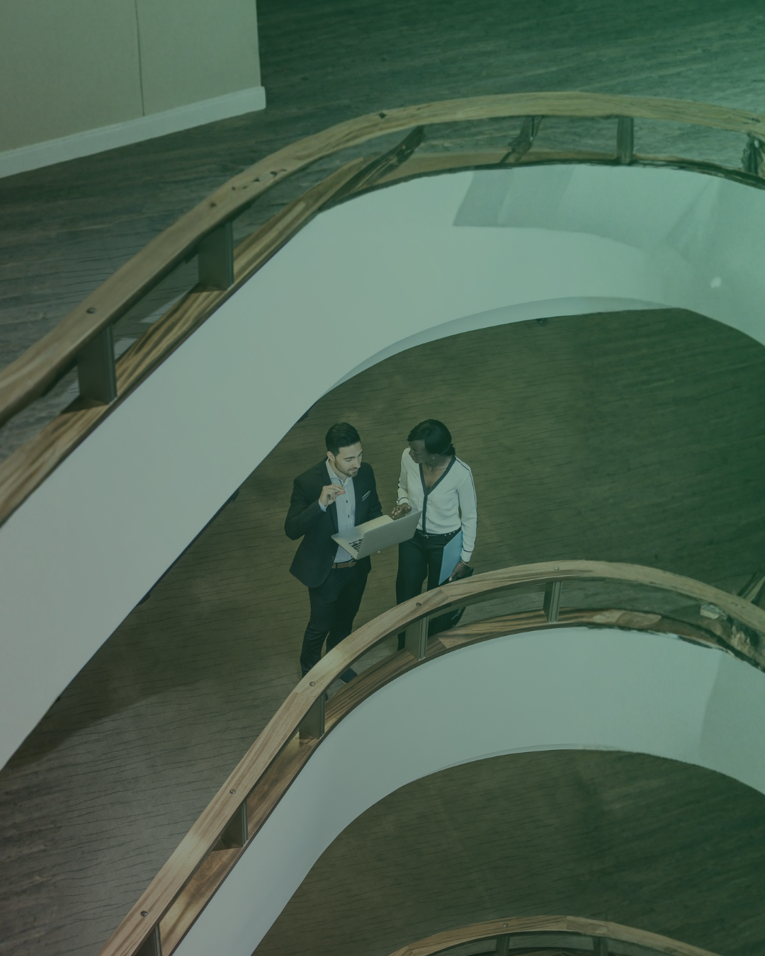 two real estate executives talking over a lap top screen